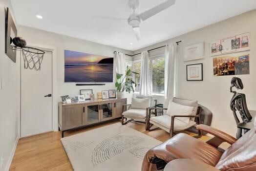 living area with light wood-type flooring and ceiling fan