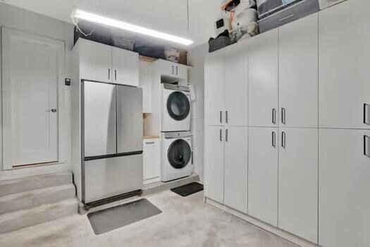 laundry room with stacked washing maching and dryer