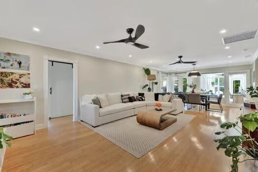 living room featuring light hardwood / wood-style flooring and ceiling fan