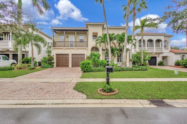 mediterranean / spanish-style home featuring a balcony, a garage, and a front lawn