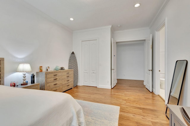 bedroom featuring a closet, crown molding, hardwood / wood-style floors, and ensuite bathroom