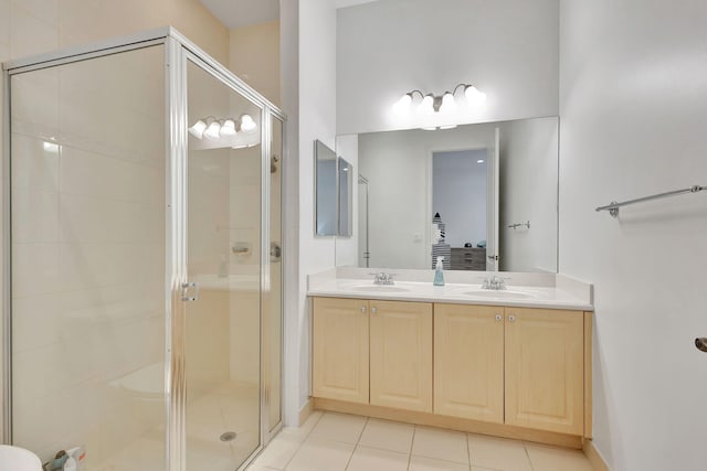 bathroom with tile patterned flooring, a shower with door, and vanity