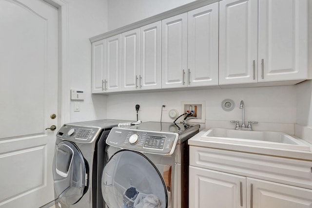 washroom with independent washer and dryer, sink, and cabinets