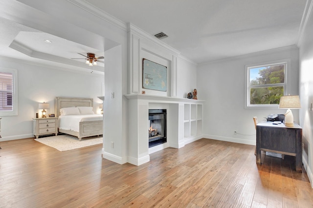 bedroom with crown molding, ceiling fan, and light hardwood / wood-style floors