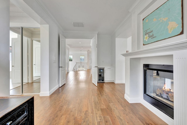 9232 Nugent Trl, West Palm Beach, FL 33411 - corridor with wine cooler, light wood finished floors, and ornamental molding