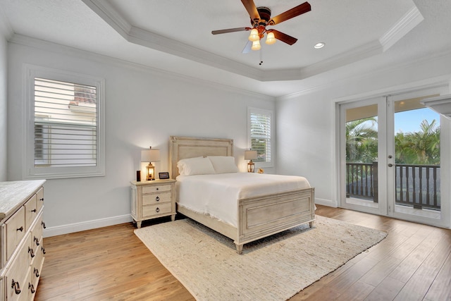 bedroom with ceiling fan, a raised ceiling, access to outside, light hardwood / wood-style flooring, and ornamental molding