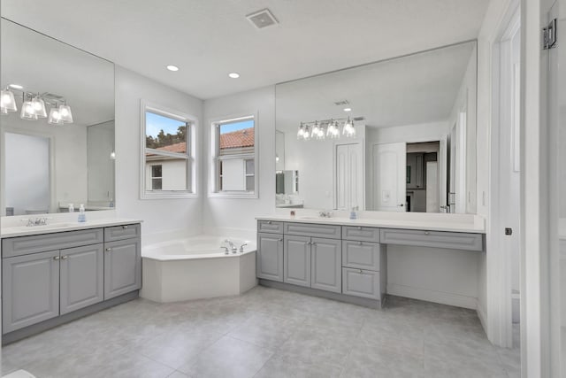 bathroom with a tub, tile patterned flooring, and vanity