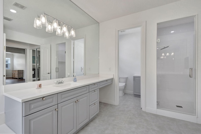 bathroom with an enclosed shower, vanity, tile patterned flooring, and toilet