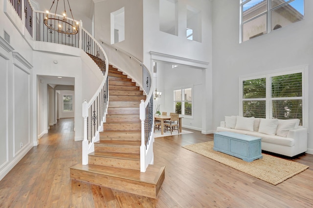 9232 Nugent Trl, West Palm Beach, FL 33411 - living area featuring a high ceiling, a chandelier, stairs, and wood-type flooring