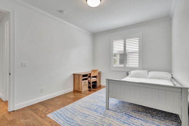 bedroom featuring ornamental molding, hardwood / wood-style flooring, and a textured ceiling