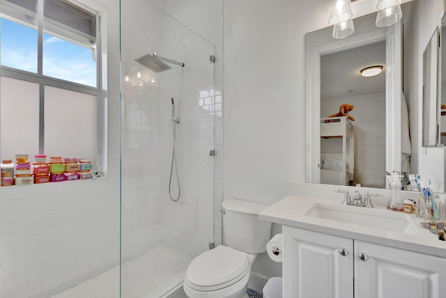 bathroom featuring vanity, a shower with shower door, and toilet