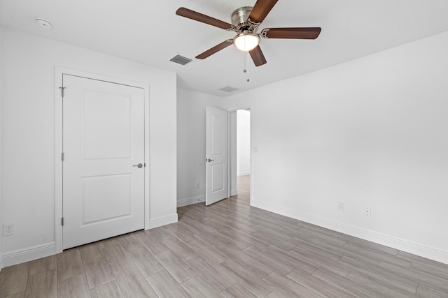 unfurnished bedroom with ceiling fan and light wood-type flooring