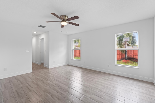 spare room featuring light hardwood / wood-style floors, a textured ceiling, and ceiling fan