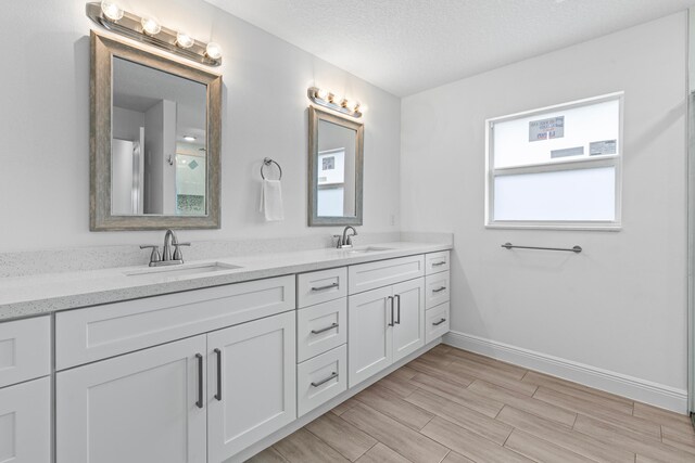 bathroom with hardwood / wood-style flooring, vanity, and a textured ceiling