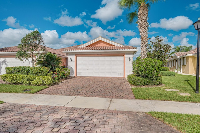 mediterranean / spanish-style house featuring a garage and a front lawn