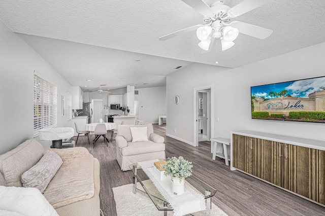 living room featuring lofted ceiling, a textured ceiling, ceiling fan, and dark hardwood / wood-style flooring