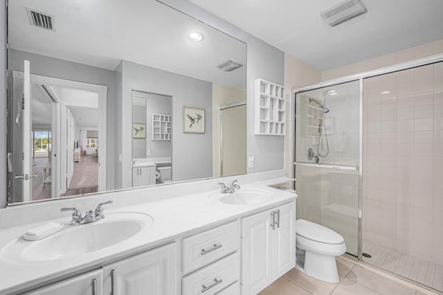 bathroom featuring vanity, a shower with shower door, toilet, and tile patterned floors