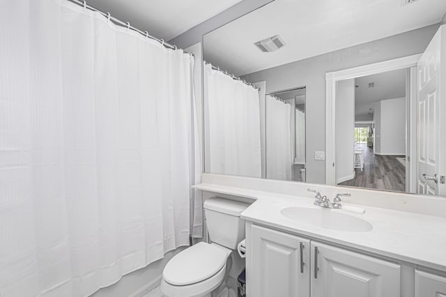 full bathroom with vanity, shower / bath combo, hardwood / wood-style flooring, and toilet