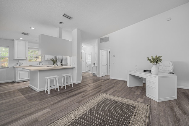 kitchen featuring stainless steel fridge with ice dispenser, kitchen peninsula, white cabinetry, and dark hardwood / wood-style flooring