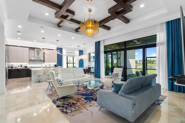 living area featuring marble finish floor, coffered ceiling, beamed ceiling, and ceiling fan with notable chandelier