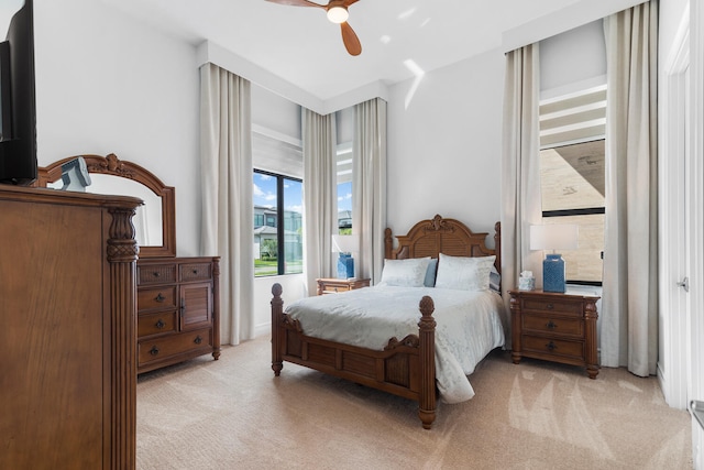 bedroom with a ceiling fan and light colored carpet