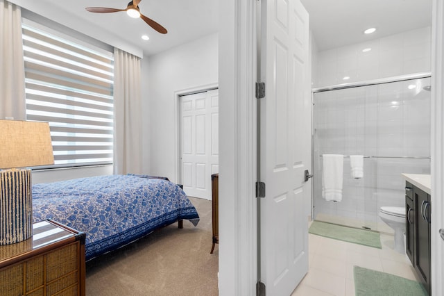 bedroom featuring light tile patterned floors, a ceiling fan, light colored carpet, ensuite bath, and recessed lighting