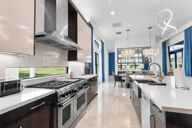 kitchen featuring visible vents, wall chimney exhaust hood, modern cabinets, appliances with stainless steel finishes, and light countertops