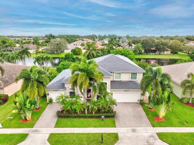 9863 Royal Cardigan Way, West Palm Beach, FL 33411 - view of front of house featuring decorative driveway, stucco siding, a garage, and a front yard