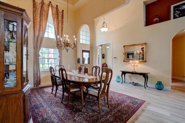 dining space featuring a high ceiling and hardwood / wood-style flooring