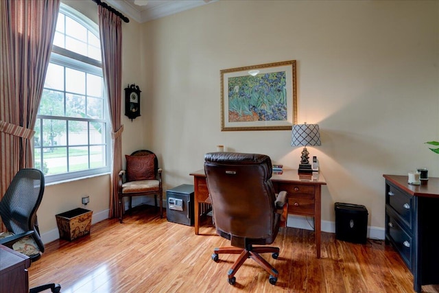 home office featuring ornamental molding and light hardwood / wood-style floors