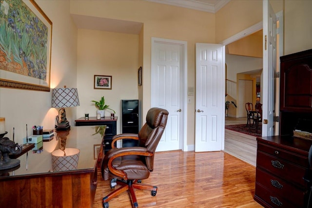 home office with ornamental molding and light hardwood / wood-style flooring