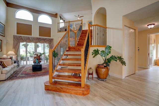 stairs featuring a towering ceiling and hardwood / wood-style floors