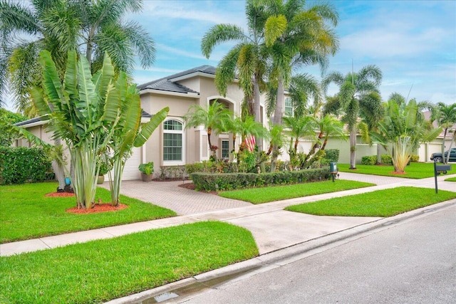 mediterranean / spanish home with a garage and a front lawn