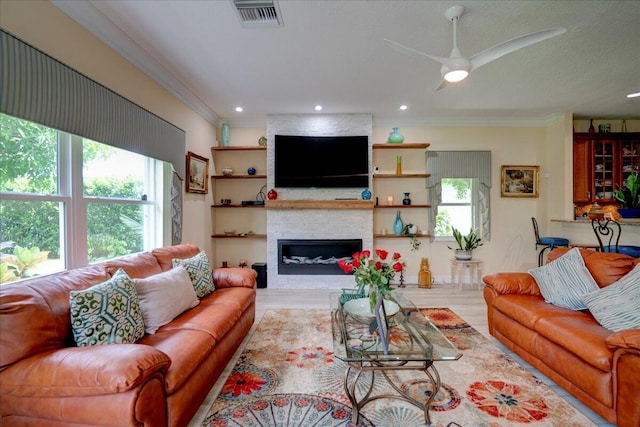 living room with plenty of natural light, a large fireplace, and light hardwood / wood-style flooring