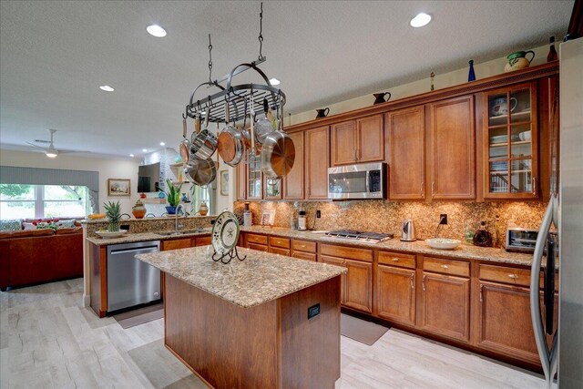 9863 Royal Cardigan Way, West Palm Beach, FL 33411 - kitchen featuring a sink, a kitchen island, light stone countertops, a textured ceiling, and recessed lighting