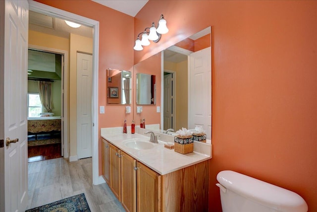 bathroom with wood-type flooring, vanity, and toilet