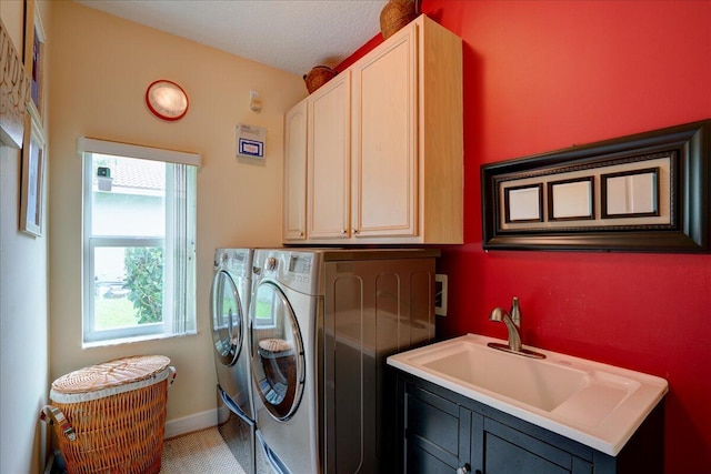 washroom with separate washer and dryer, cabinets, sink, and a textured ceiling