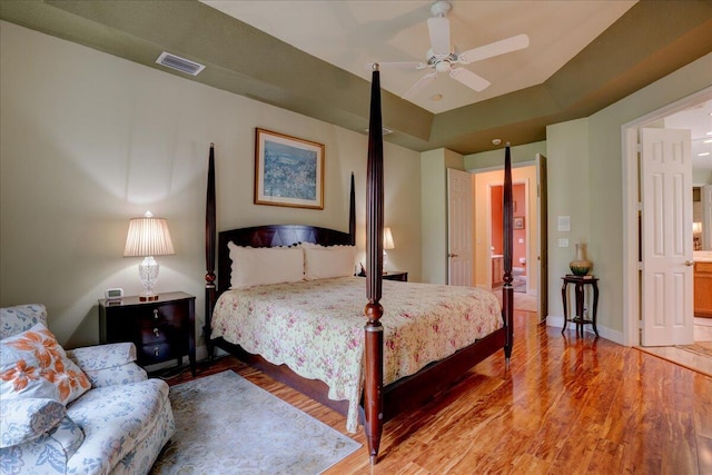 bedroom featuring ceiling fan, ensuite bathroom, and wood-type flooring