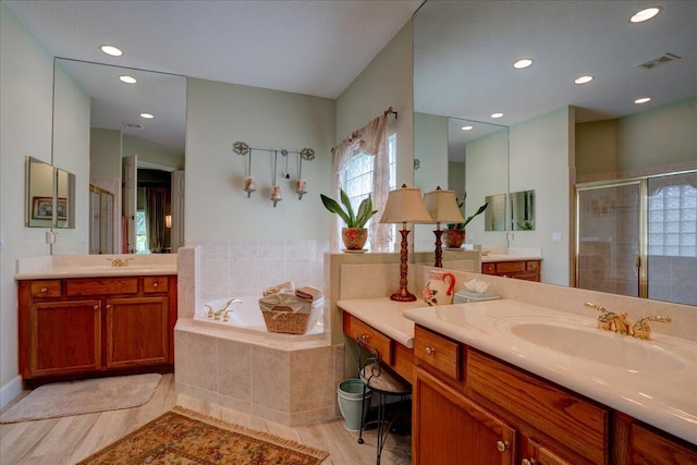 bathroom with vanity, shower with separate bathtub, and hardwood / wood-style floors