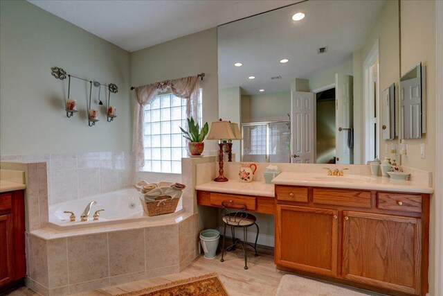 9863 Royal Cardigan Way, West Palm Beach, FL 33411 - bathroom featuring a stall shower, a bath, wood finished floors, recessed lighting, and two vanities