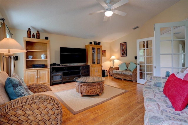 living room featuring ceiling fan, lofted ceiling, and light hardwood / wood-style floors