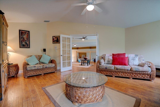 living room featuring ceiling fan, hardwood / wood-style flooring, lofted ceiling, and french doors