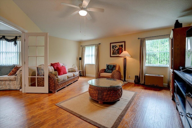 living room featuring a textured ceiling, hardwood / wood-style floors, a wealth of natural light, and ceiling fan