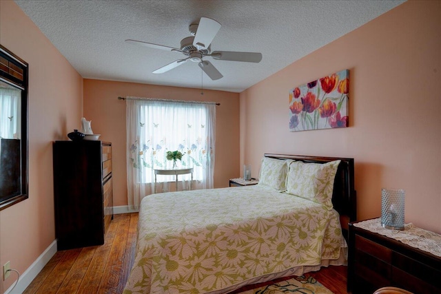 bedroom featuring light wood-type flooring, ceiling fan, and a textured ceiling