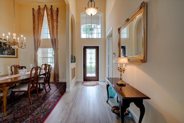 foyer featuring a high ceiling, hardwood / wood-style floors, and an inviting chandelier