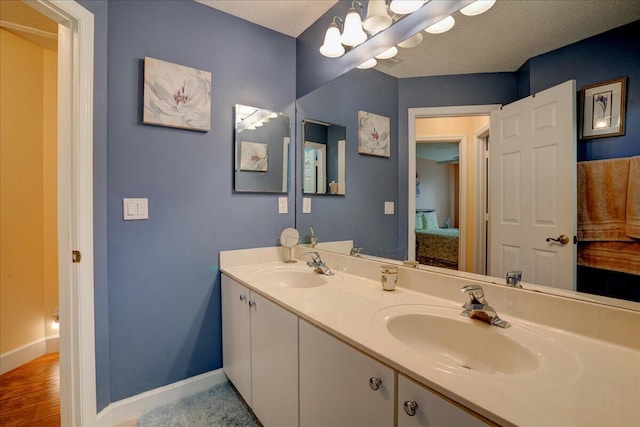 bathroom featuring vanity, wood-type flooring, and a textured ceiling