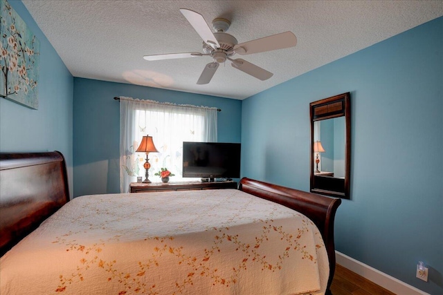 bedroom featuring ceiling fan, wood-type flooring, and a textured ceiling