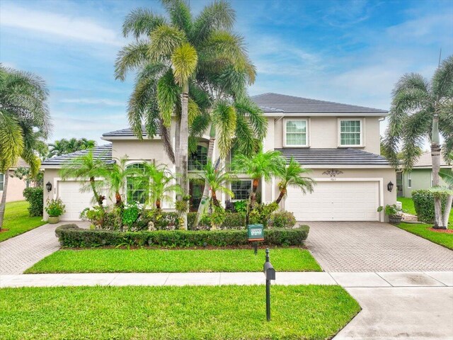 9863 Royal Cardigan Way, West Palm Beach, FL 33411 - view of front of property featuring decorative driveway, a garage, stucco siding, and a front lawn