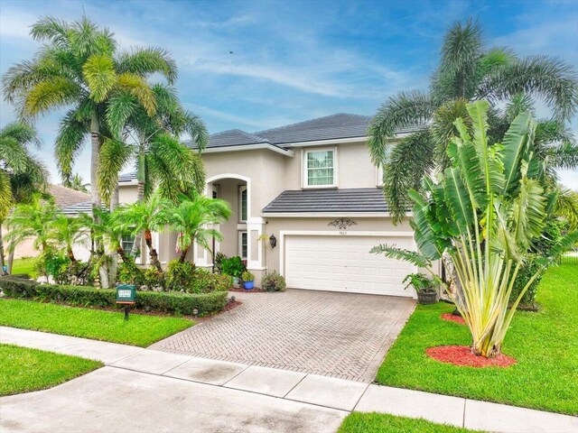 9863 Royal Cardigan Way, West Palm Beach, FL 33411 - view of front of home featuring decorative driveway, stucco siding, a water view, and a tiled roof