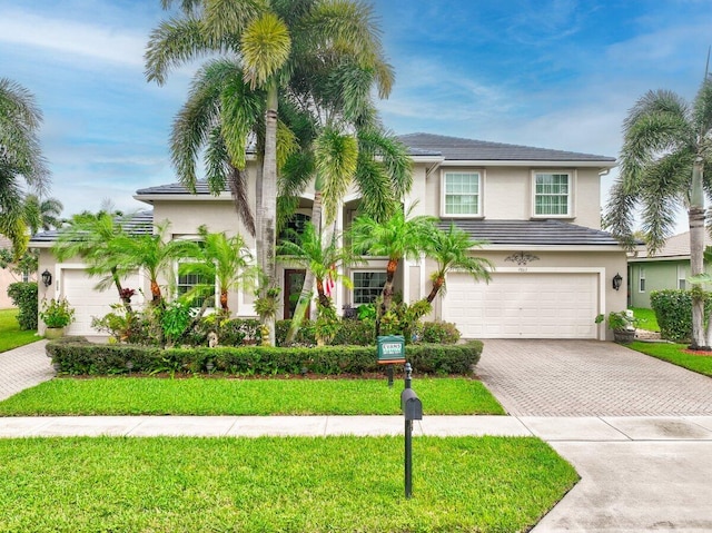 9863 Royal Cardigan Way, West Palm Beach, FL 33411 - view of front of house featuring decorative driveway, stucco siding, a garage, and a front lawn